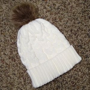 White knit hat with brown puff
